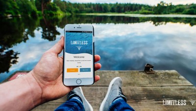A man using the Limitless Technology Crowdsourcing Customer Service app in front of a lake.